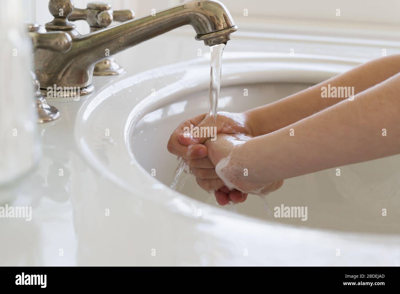 Gros plan de la fille (6-7) se laver les mains Banque D'Images