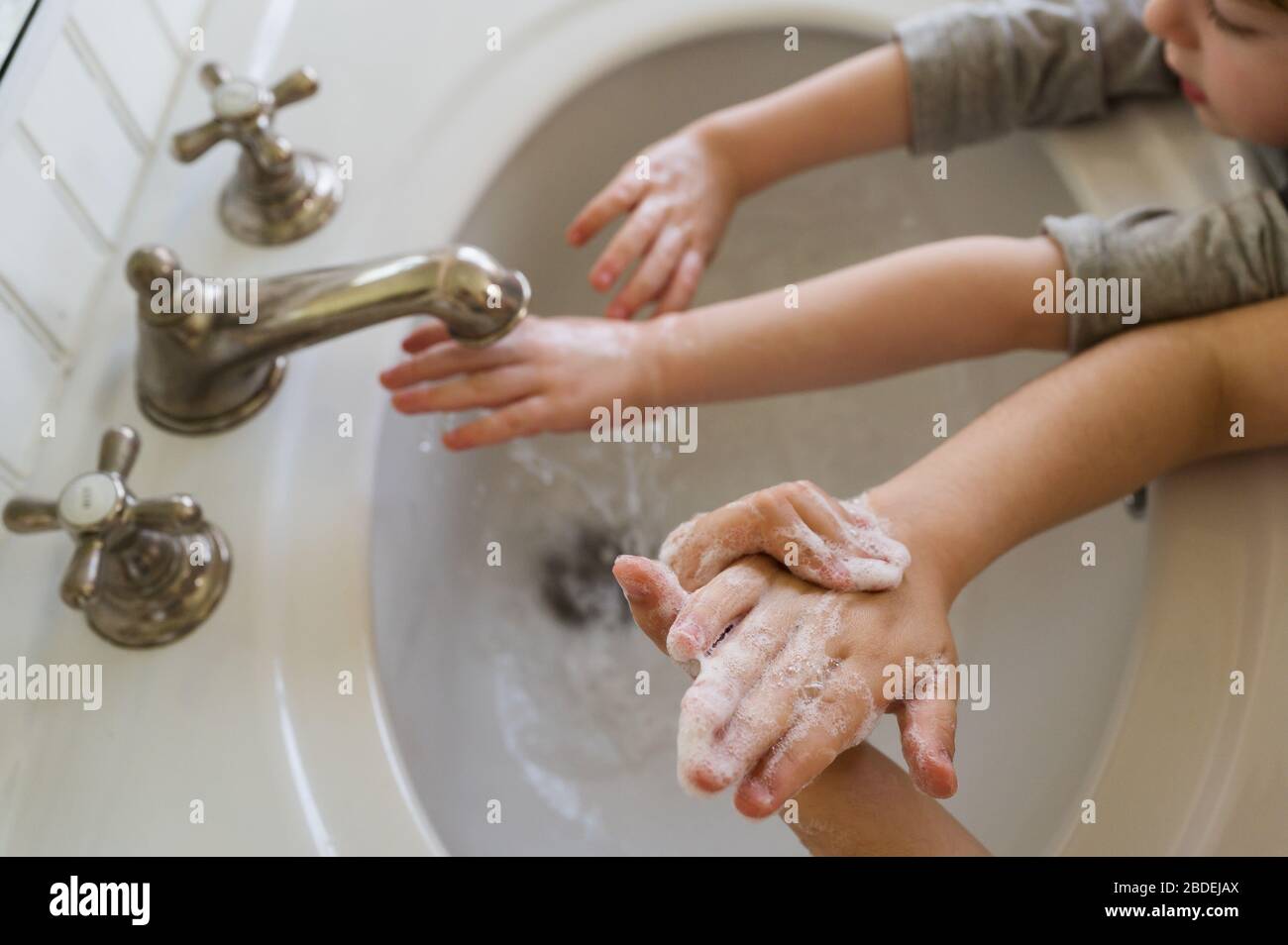Gros plan des enfants (4-5, 6-7) se lavant les mains Banque D'Images