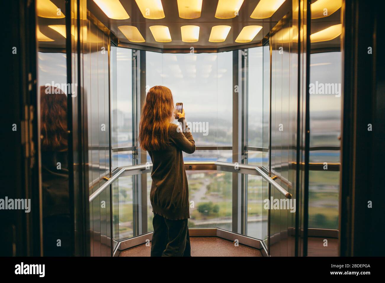 Biélorussie, Minsk, femme debout dans un ascenseur transparent Banque D'Images