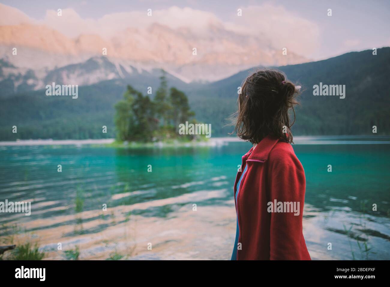 Allemagne, Bavière, Eibsee, jeune femme se tenant au lac d'EibseeÂ dans les Alpes bavaroises et regardant la vue Banque D'Images