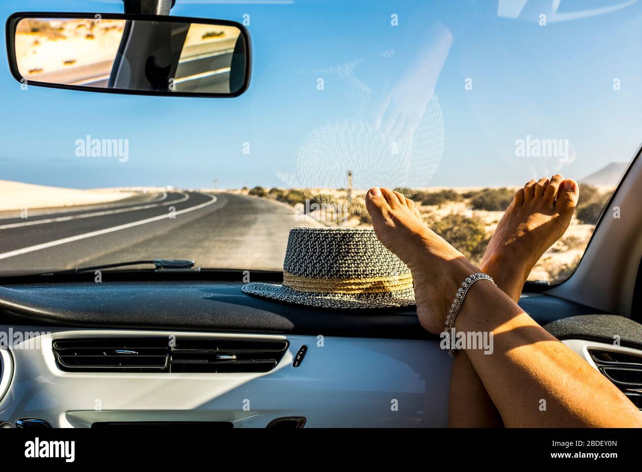 Point de vue des jambes des femmes à l'intérieur d'un véhicule de voiture et de la route extérieure en arrière-plan - les gens voyagent concept en véhicule pour des vacances d'été ou adve Banque D'Images