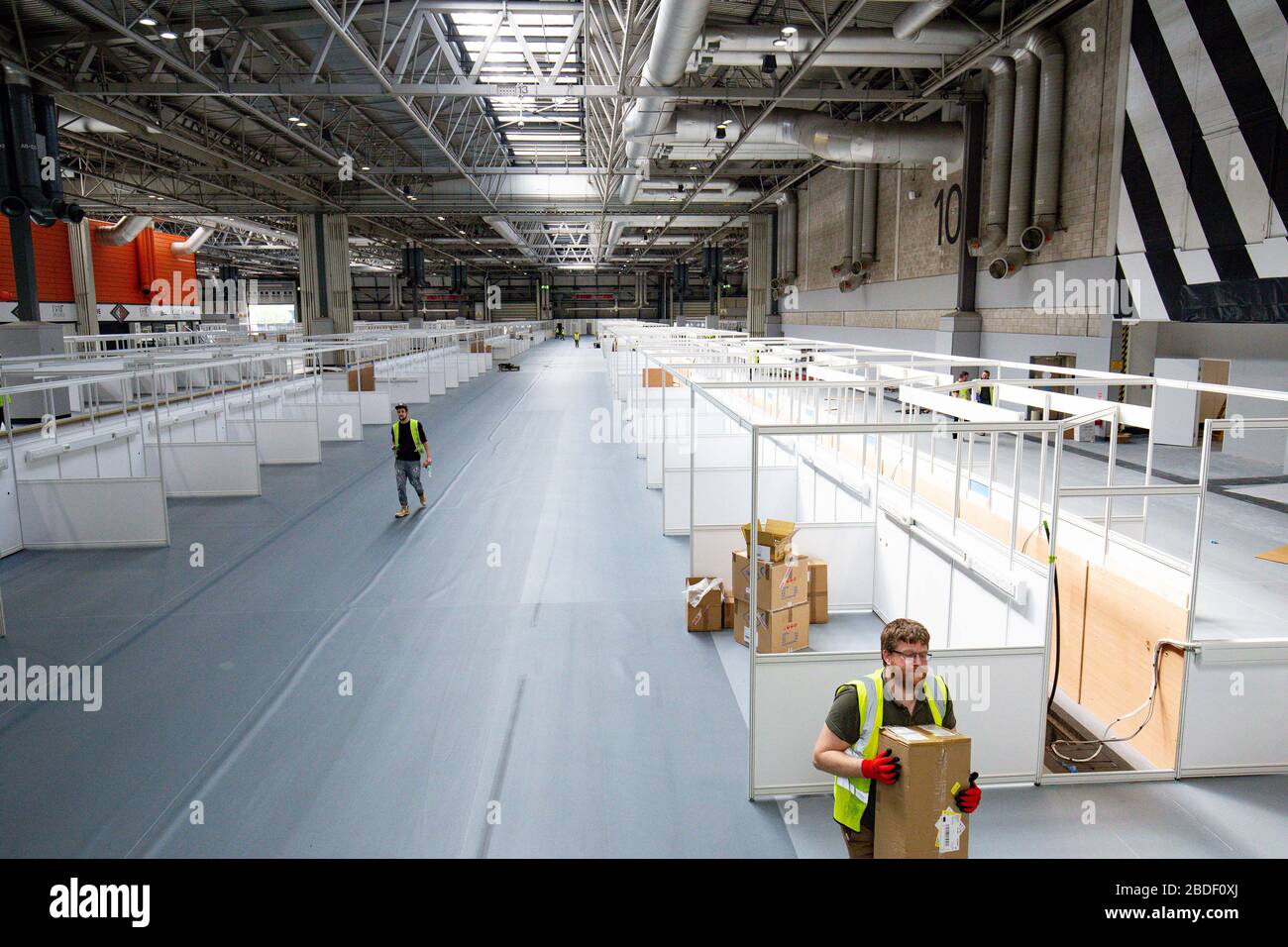 Le travail se poursuit au nouvel hôpital temporaire NHS Nightingale Birmingham du NEC de Birmingham, qui est en cours de construction pour fournir des soins à un nombre accru de patients nécessitant un traitement pendant la pandémie COVID-19. Banque D'Images