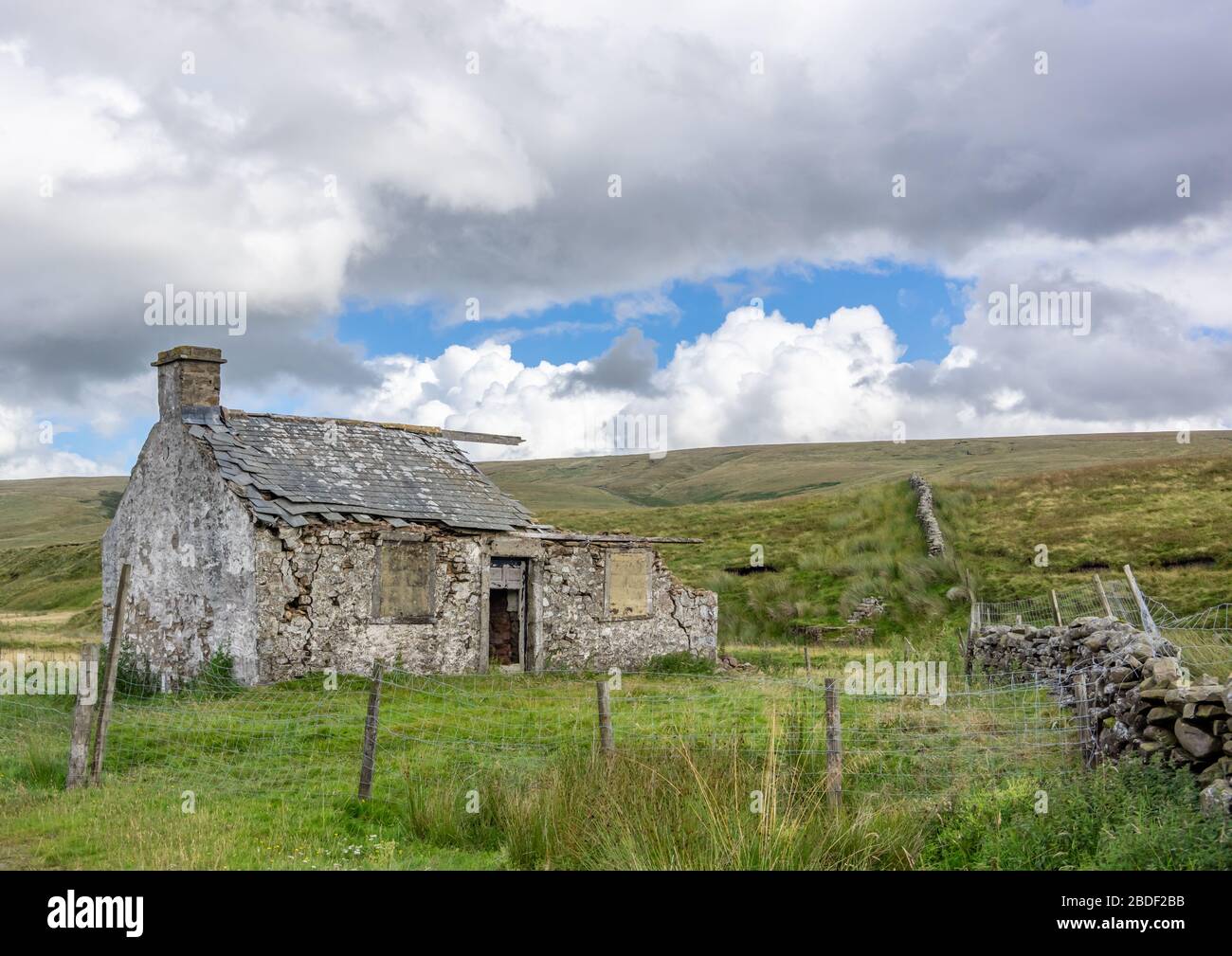 Un cottage ferme construit en pierre à l'origine de la pierre abandonnée situé dans les magnifiques Yorkshire Dales avec un ciel nuageux. Banque D'Images