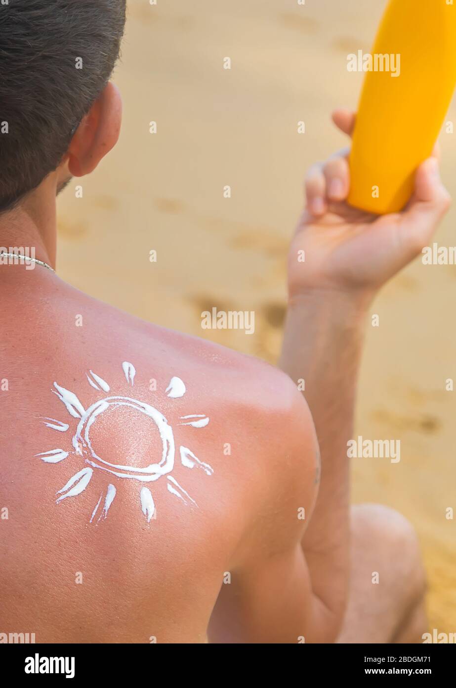 Un homme sur la plage avec un écran solaire sur son dos. Focus sélectif. Les voyages. Banque D'Images