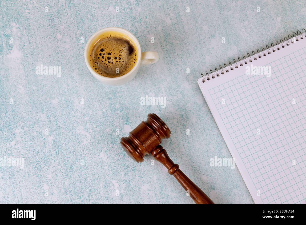 Table de bureau avec des accessoires plats sur un bloc-notes en spirale une tasse de café, juge le bureau de justice juridique de la gavel Banque D'Images