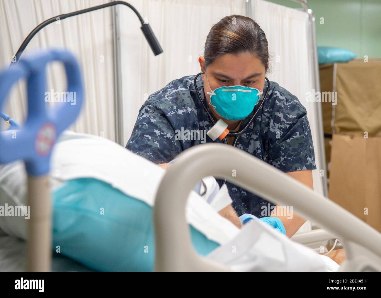Hôpital de la marine américaine Corpsman 1ère classe Leslie Simmons, effectue une évaluation sur un patient de soins respiratoires à bord du navire hospitalier USNS Mercy déployé à l'appui de la COVID-19, pandémie de coronavirus amarrée le 7 avril 2020 à Los Angeles, Californie. Banque D'Images
