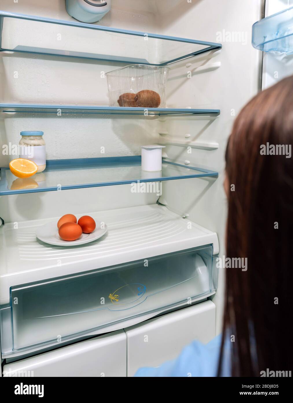 Fille regardant un frigo vide en raison d'une crise Photo Stock - Alamy