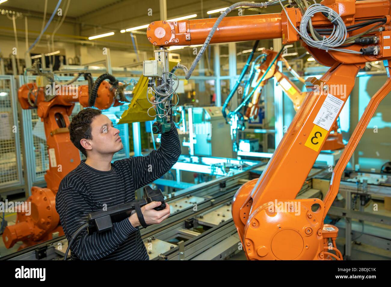 programmation des bras de robot pour un nouveau produit par un ingénieur de production Banque D'Images