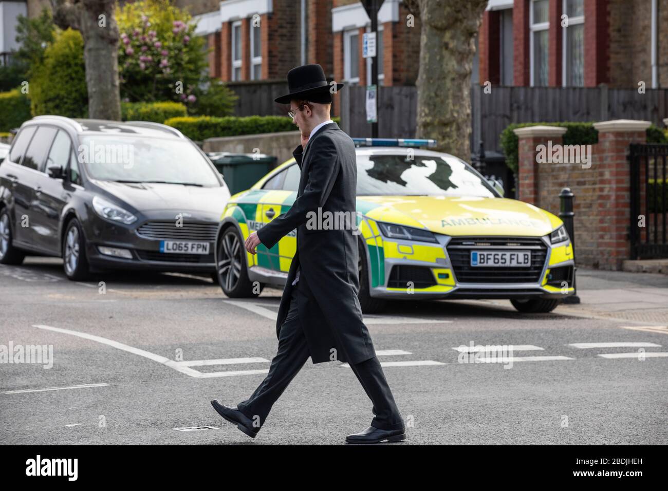 Juif ultra-orthodoxe dans la communauté juive de Stamford Hill en passant une ambulance devant les célébrations de la Pâque pendant le COVID-19, a verrouillé le Royaume-Uni Banque D'Images