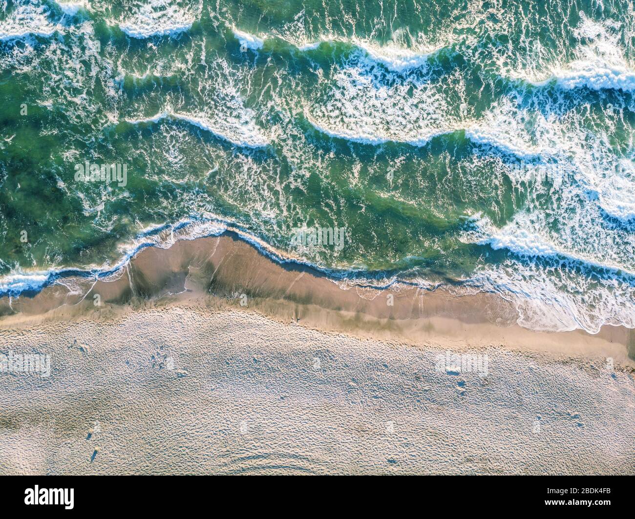 Vue aérienne de s'écraser dans l'océan avec des vagues de lumière au ...