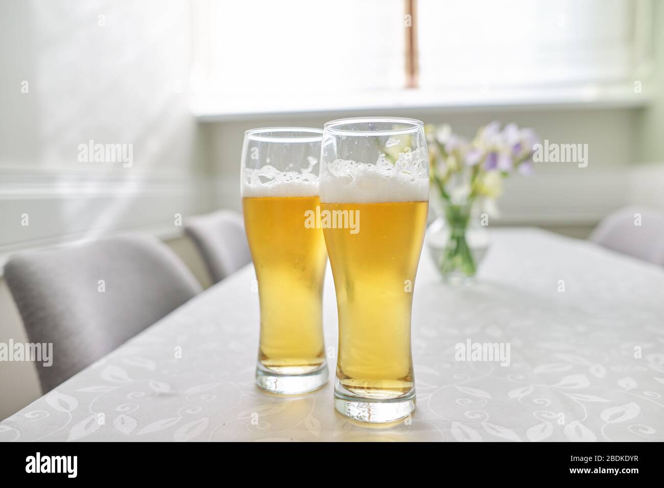 Deux verres de bière sur la table, table maison avec chaises près de la fenêtre Banque D'Images