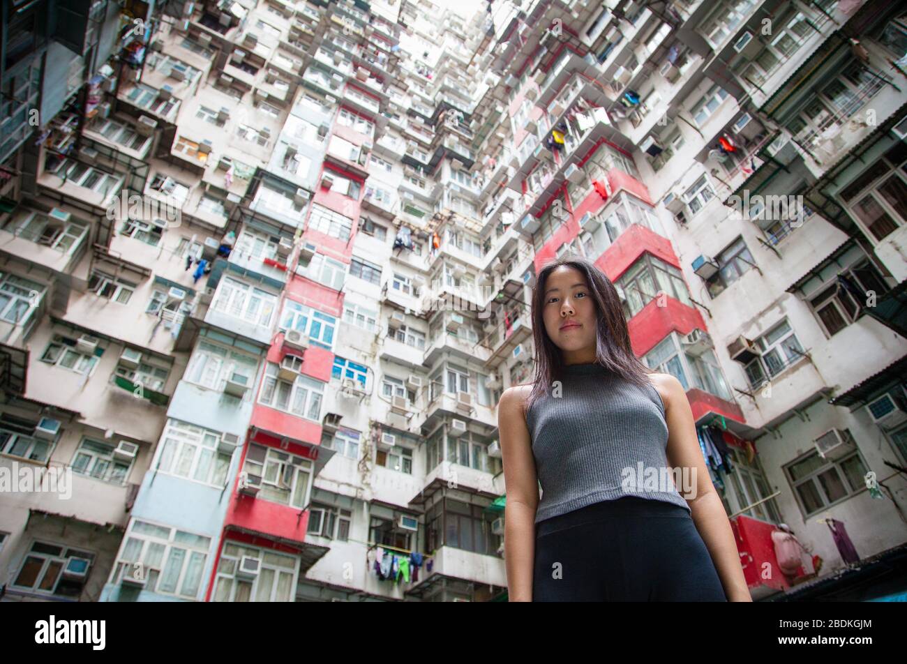 Une jeune fille chinoise explorant le paysage urbain des quartiers de logements publics crammés de Hong Kong à Quarry Bay, sur l'île de Hong Kong Banque D'Images