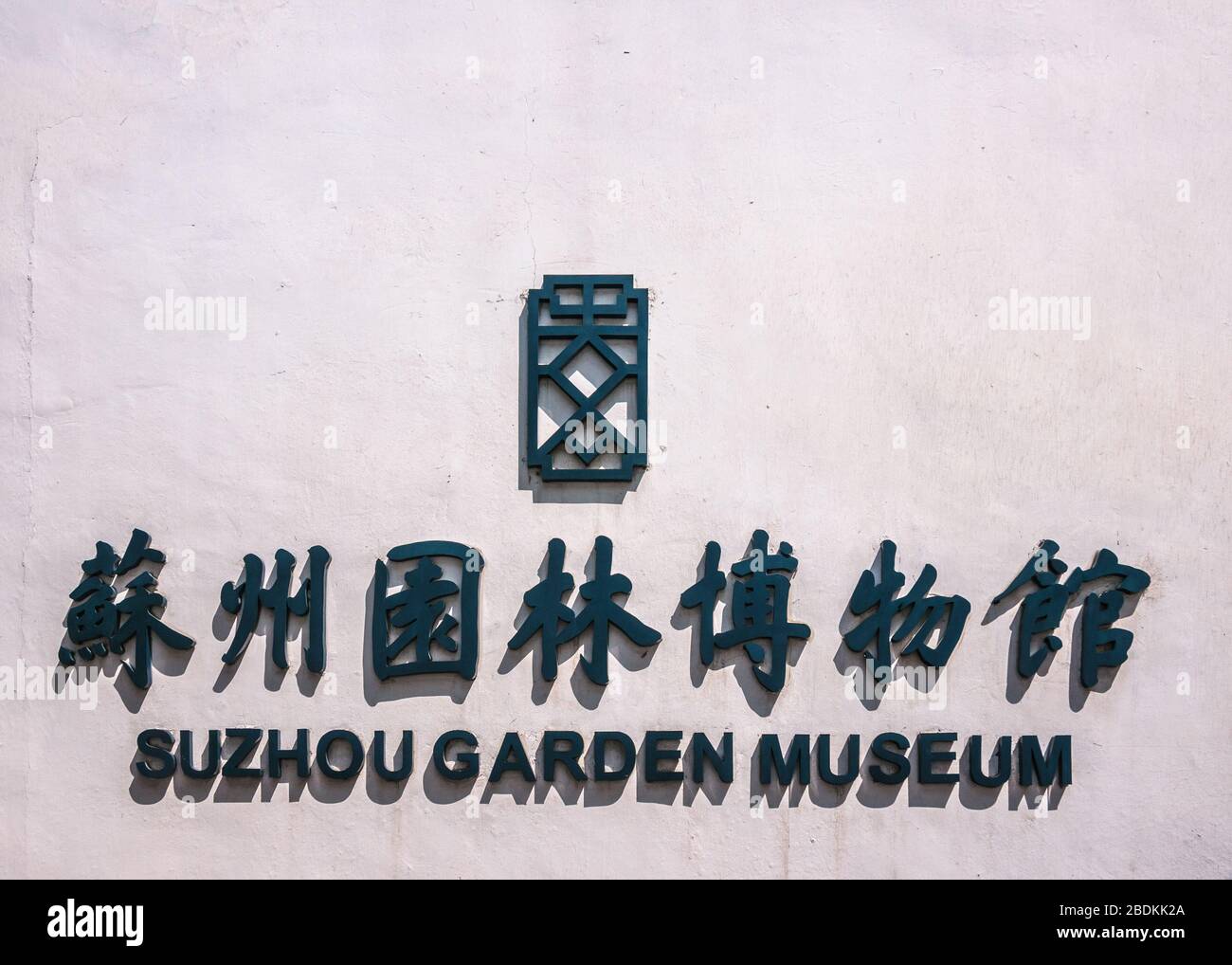 Suzhou Chine - 3 mai 2010: Gros plan de lettres et de symboles noirs sur le mur blanc pour le musée du jardin de Suzhou. Le soleil provoque des ombres. Banque D'Images