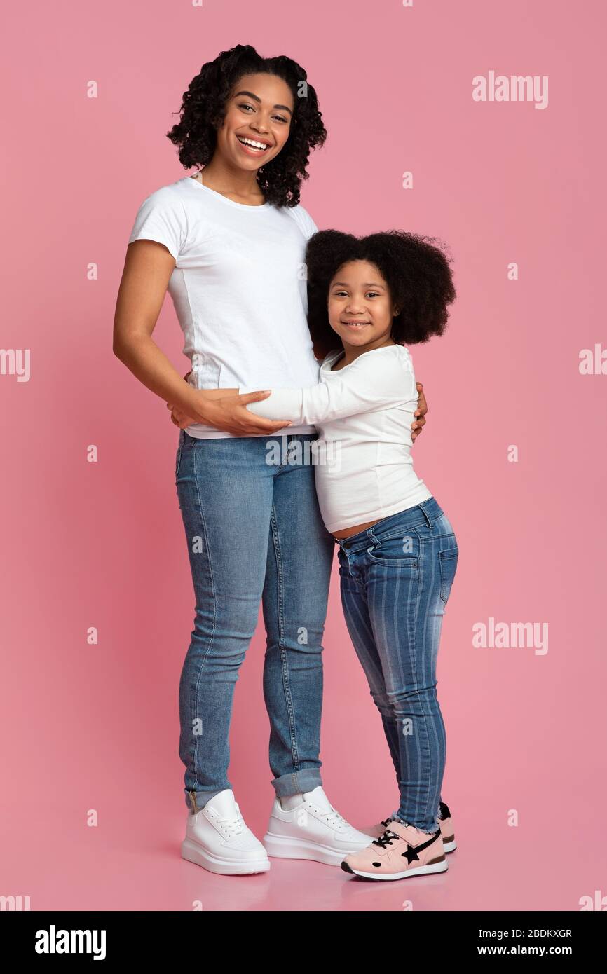 Connexion de la fille mère. Mignonne petite fille noire Cudling son maman affectueuse Banque D'Images