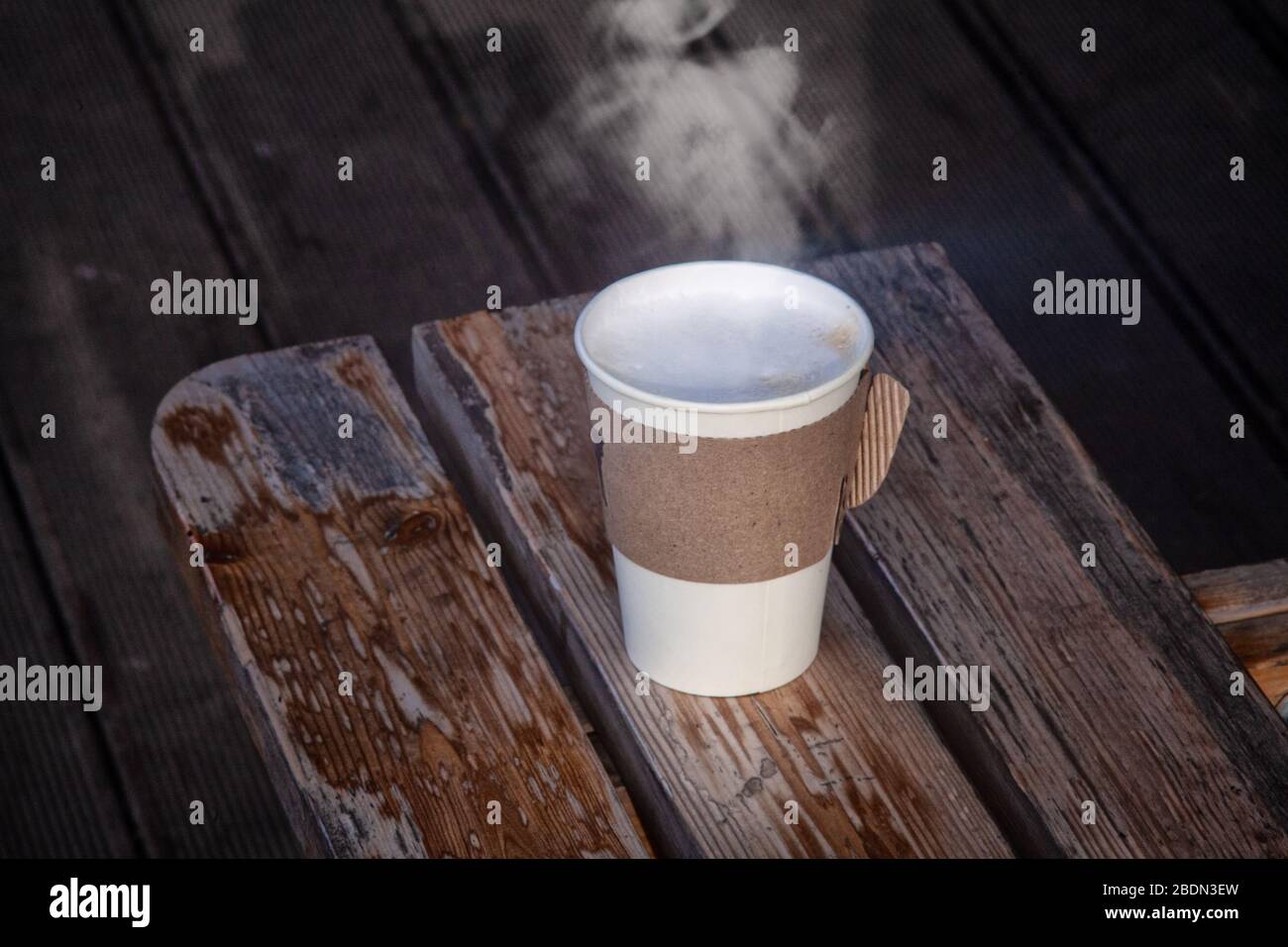 Tasse de café à emporter en papier avec de la vapeur chaude sur la table en bois Banque D'Images