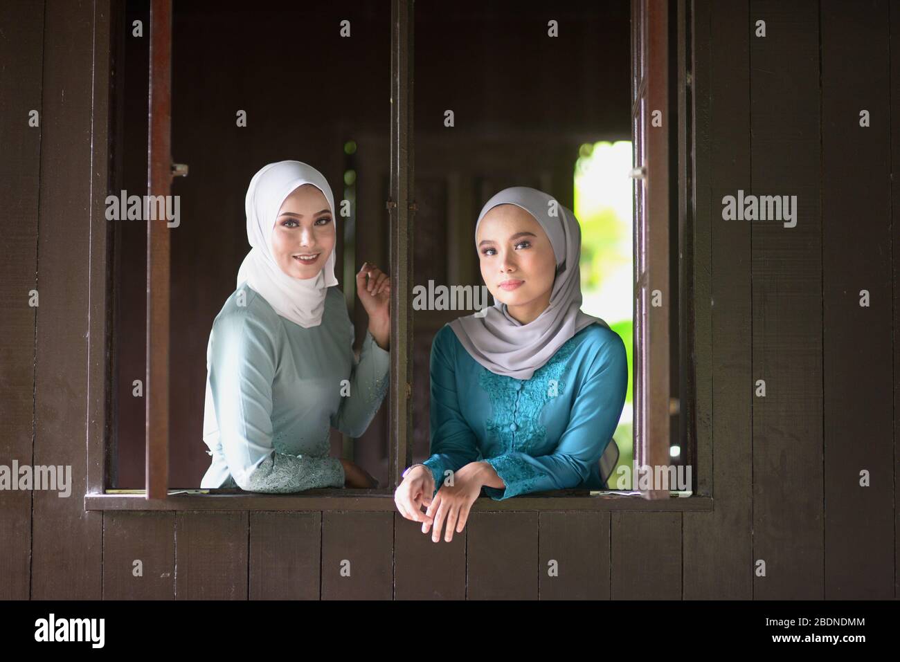 Portrait de filles musulmanes en hijab souriant à la maison traditionnelle en bois. Banque D'Images