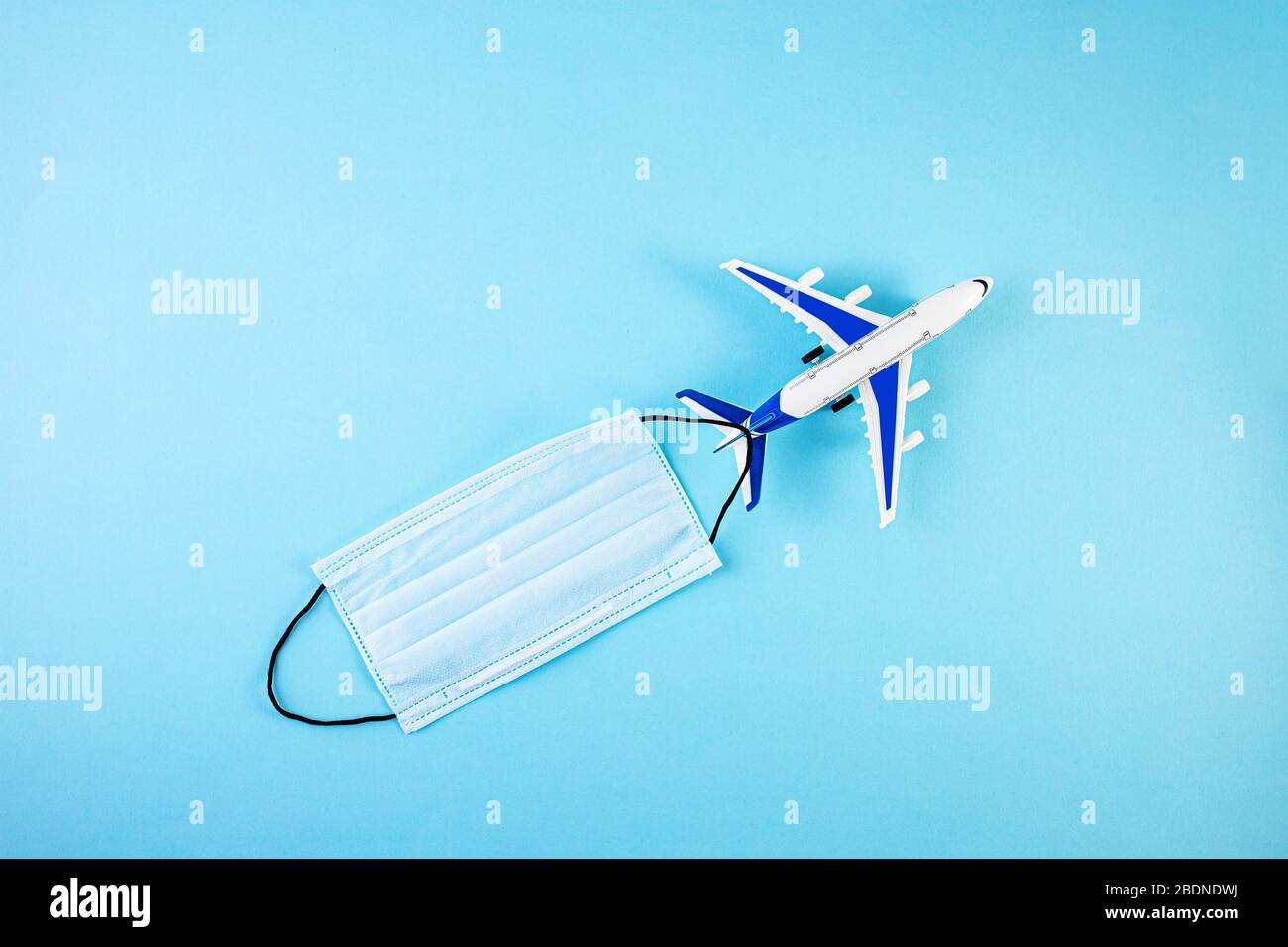 Modèle d'avion avec masque médical de protection. Concept de quarantaine du coronavirus pandémique Covid-19. Équipement de protection individuelle. Auto-isolation Banque D'Images