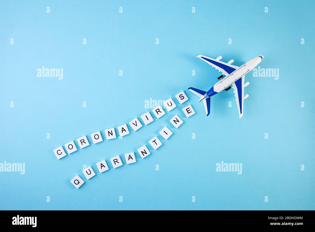 Avion avec les mots quarantaine et coronavirus écrit sur un fond bleu. Concept de quarantaine du coronavirus pandémique Covid-19 Banque D'Images