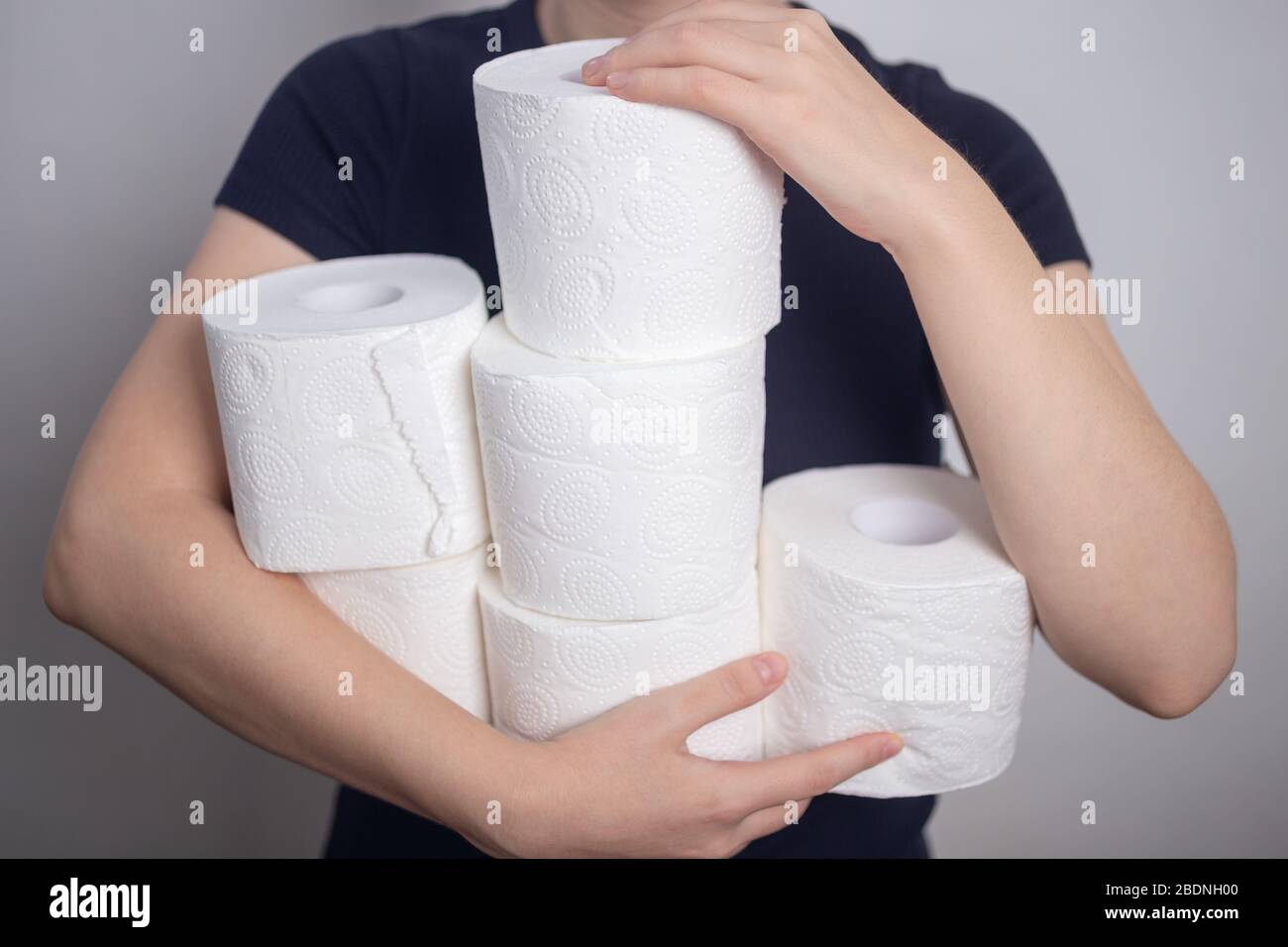 Les mains de la femme tiennent de nombreux rouleaux de papier toilette. Hoarding de panique, achat pour la quarantaine de coronavirus Banque D'Images