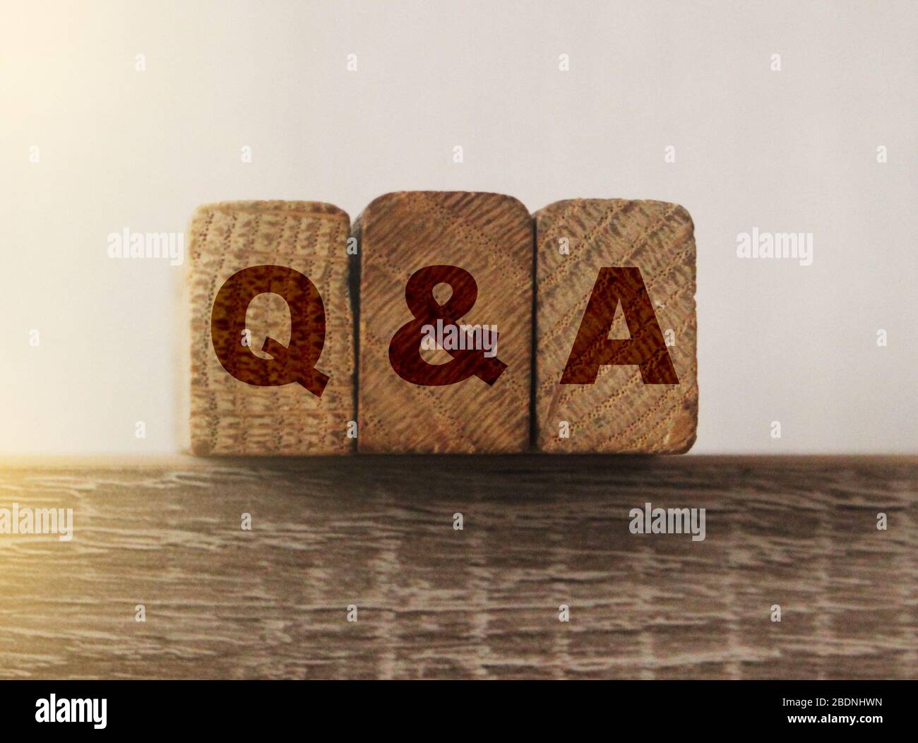 Gros plan de Q et une cale en bois. Concept de questions et réponses supprot. Client Banque D'Images