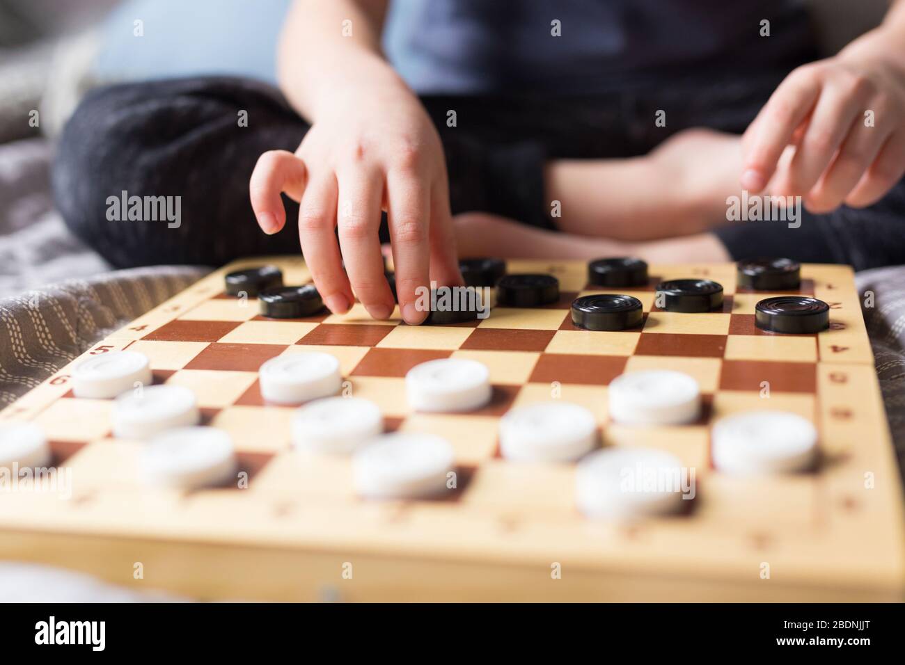 Concept de quarantaine pour rester à la maison. Les jeunes enfants jouent à des jeux de table sur le lit. Jeu de société et concept de loisirs pour enfants. Heure de la famille. Banque D'Images