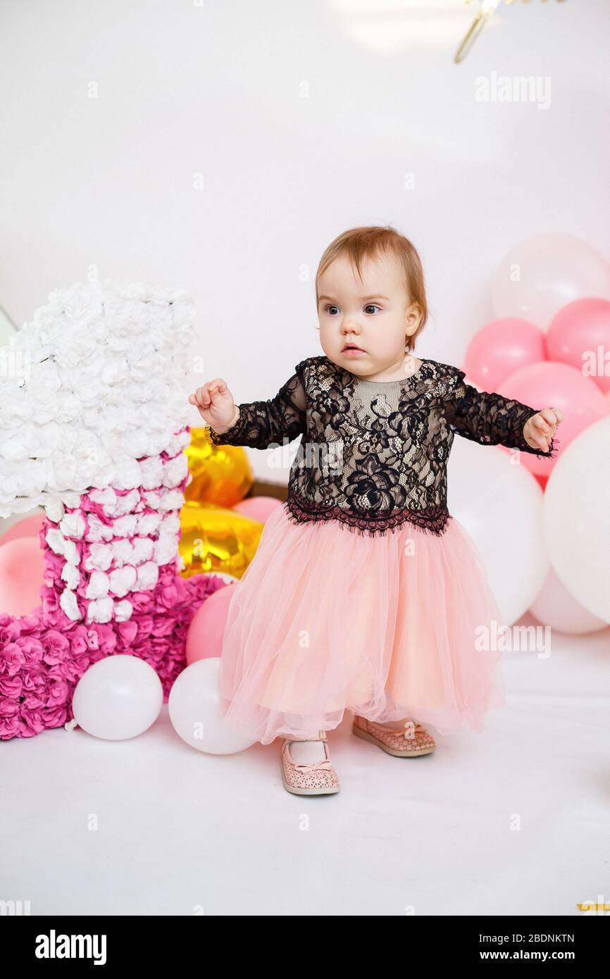 Photo portrait d'une fille d'anniversaire 1 an dans une robe rose avec des  ballons roses. L'enfant en vacances sourit, les émotions des enfants. Fête  d'anniversaire Photo Stock - Alamy