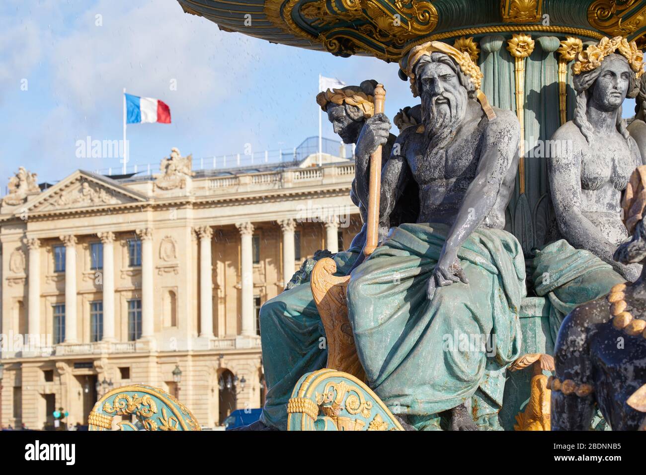 La place de la Concorde fontaine statues avec des détails dorés et bâtiment avec drapeau français dans une journée ensoleillée à Paris Banque D'Images