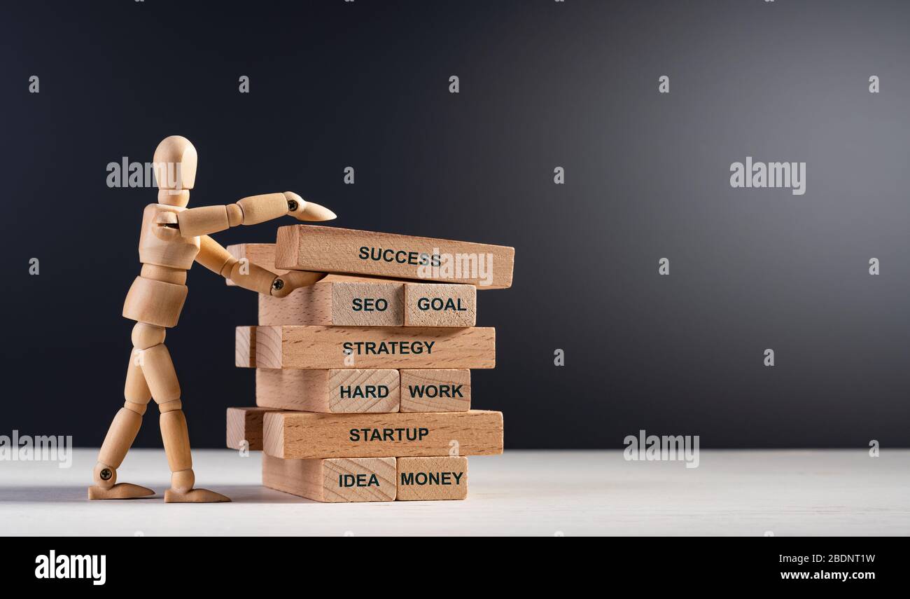 Homme en bois construire tour de longues briques en bois avec des mots. Construire votre avenir. Concept de succès, travail d'équipe, motivation, objectif de vision, A Banque D'Images