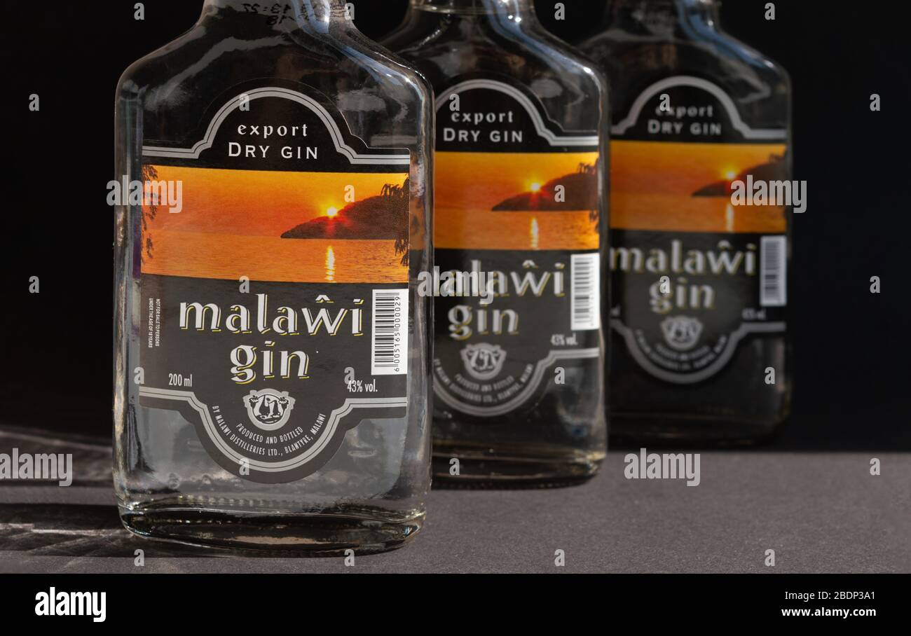 KIEV, UKRAINE - 03 AVRIL 2020: Gros plan de trois bouteilles de verre de 200 ml de gin Malawi en ligne sur un fond sombre. Un ressortissant malawian africain Banque D'Images