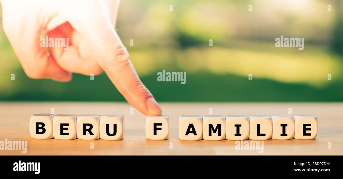 Travail ou famille? Un doigt pousse la lettre F loin du mot allemand 'Beruf' ('work') vers le mot 'Familie' ('family'). Un symbole pour la vie professionnelle Banque D'Images