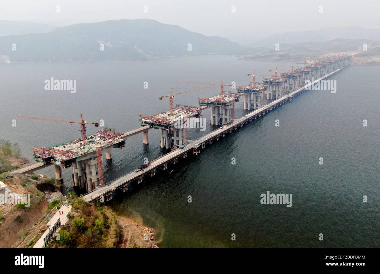 Zhengzhou. 9 avril 2020. La photo aérienne prise le 9 avril 2020 montre le chantier d'un pont de l'autoroute Mianchi-Yuanqu au-dessus de la rivière jaune, province du Henan au centre de la Chine. Le pont est une importante voie express interprovinciale reliant les provinces de Shanxi et de Henan, avec une longueur design de 1 757 mètres et une largeur de 33 mètres. Le projet devrait être achevé et ouvert au trafic d'ici la fin de 2020. Crédit: Zhu Xiang/Xinhua/Alay Live News Banque D'Images