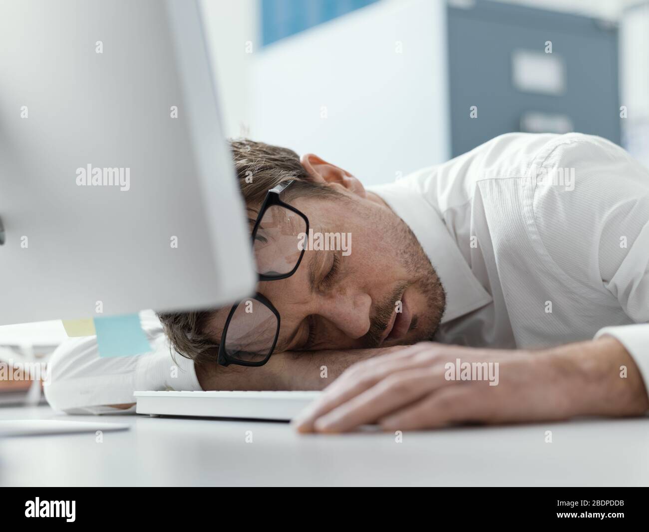 Un homme d'affaires fatigué dormait sur son bureau, le stress et le concept de surtravail Banque D'Images