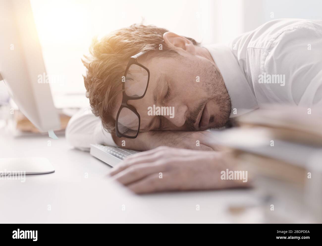 Un homme d'affaires fatigué dormait sur son bureau, le stress et le concept de surtravail Banque D'Images
