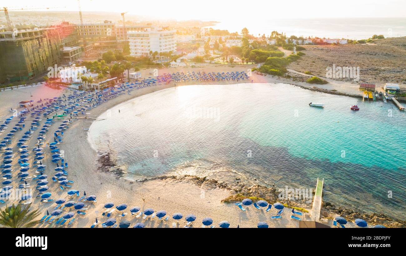 Vue panoramique sur la plage de Vathia Gonia, Ayia Napa, Famagusta, Chypre. L'attraction touristique historique baie rocheuse au lever du soleil avec sable doré, soleil Banque D'Images