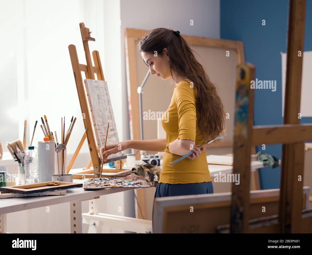 Jeune artiste créatif peinture dans le studio, elle travaille sur une peinture abstraite Banque D'Images