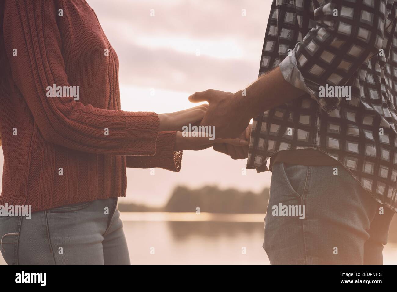 Romantique jeune couple aimant tenant les mains au lac, sentiments et les relations concept Banque D'Images