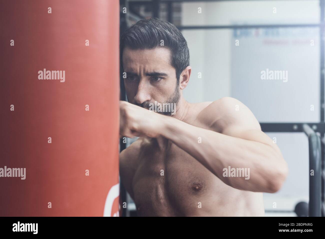 Boxer exerçant avec un sac de poinçonnage à la salle de gym, la mise au point et le concept sportif Banque D'Images