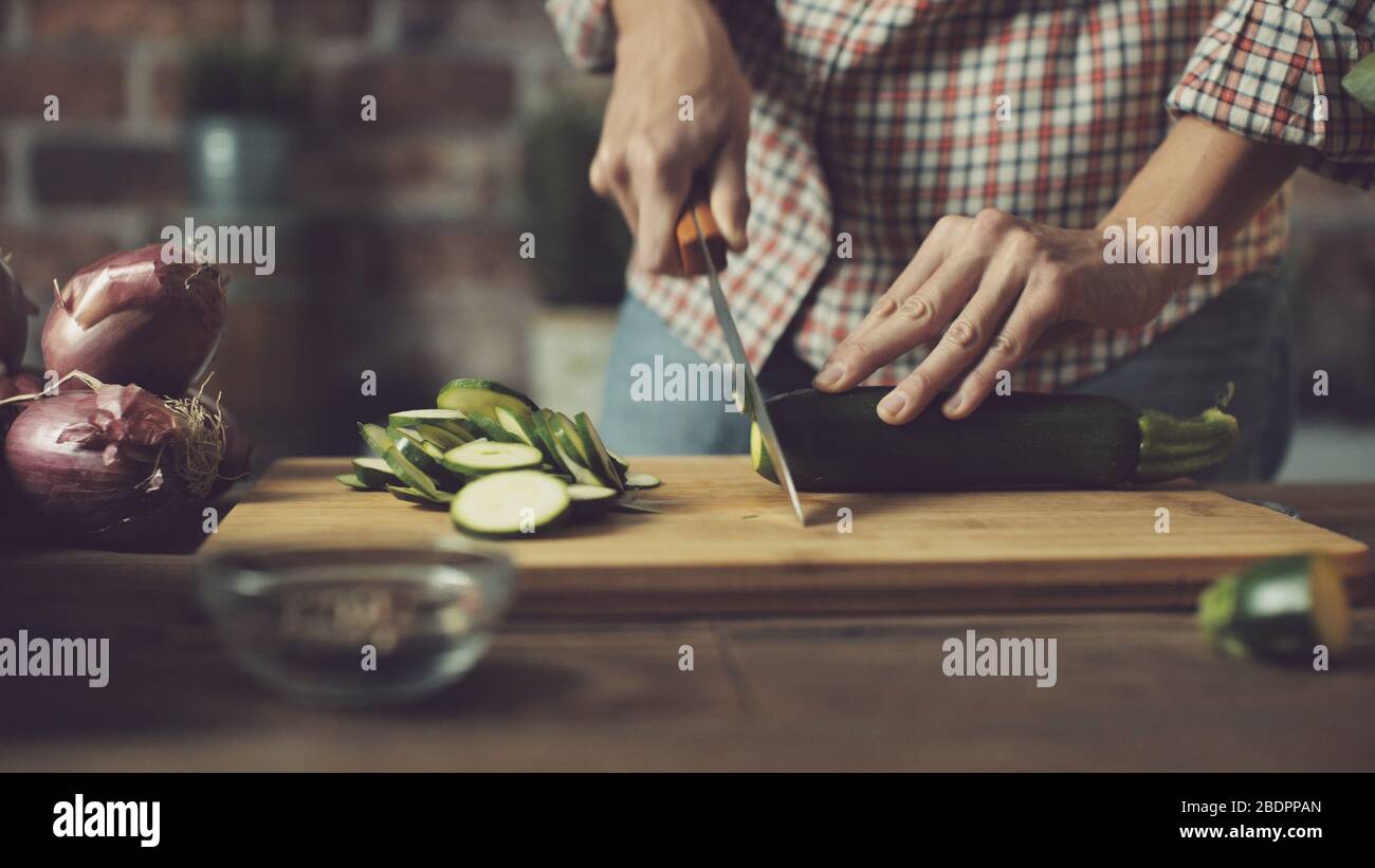 Femme préparant un repas végétalien sain, elle coupe des légumes frais sur un concept de planche à découper, de nutrition et de style de vie Banque D'Images