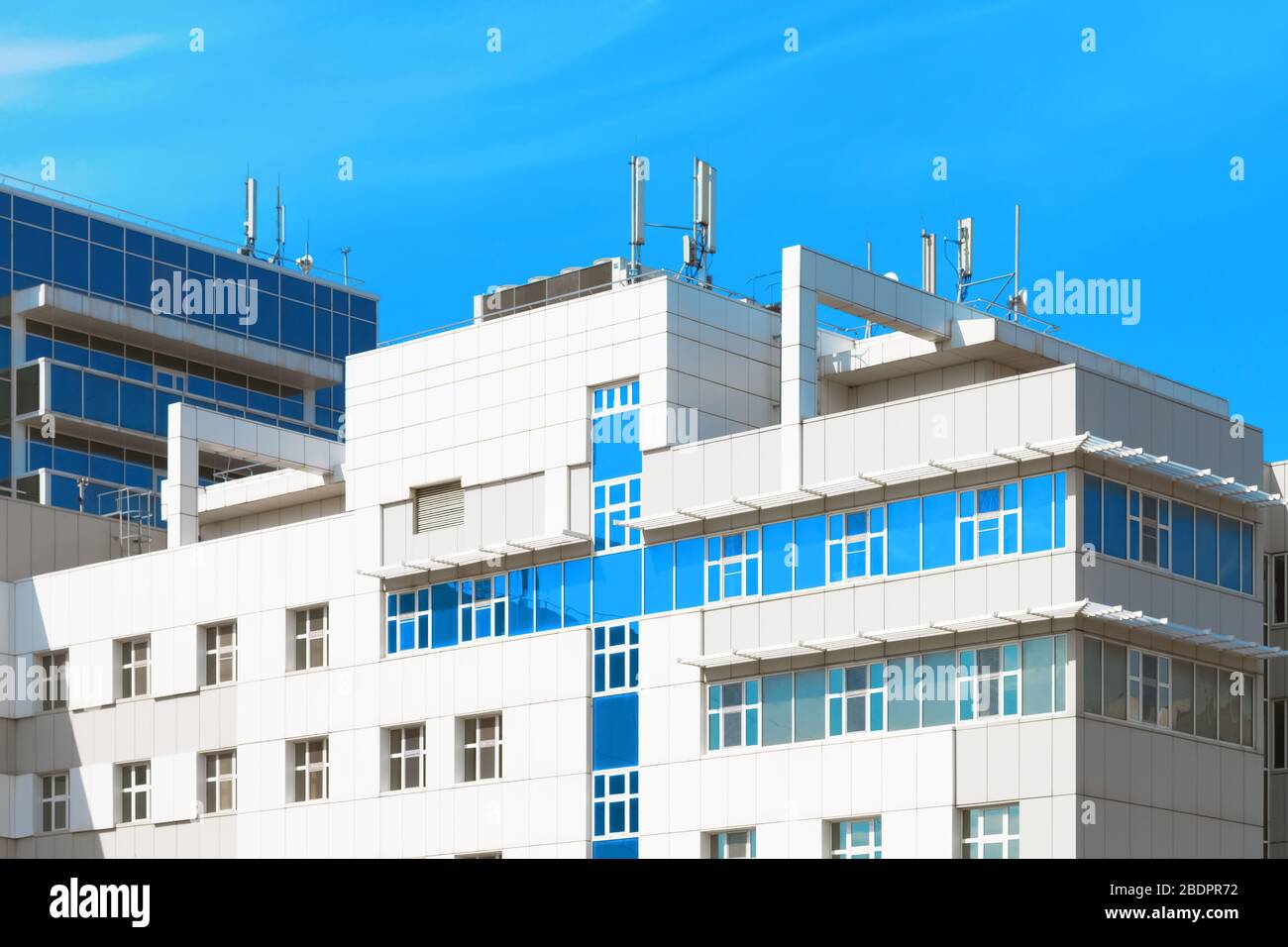 Bâtiment hospitalier moderne avec fenêtres bleues en forme de croix contre le ciel bleu Banque D'Images