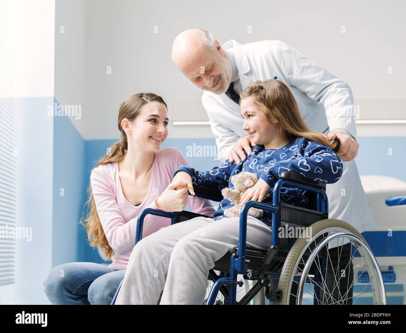 Médecin professionnel aidant une patiente en fauteuil roulant et sa mère à l'hôpital Banque D'Images