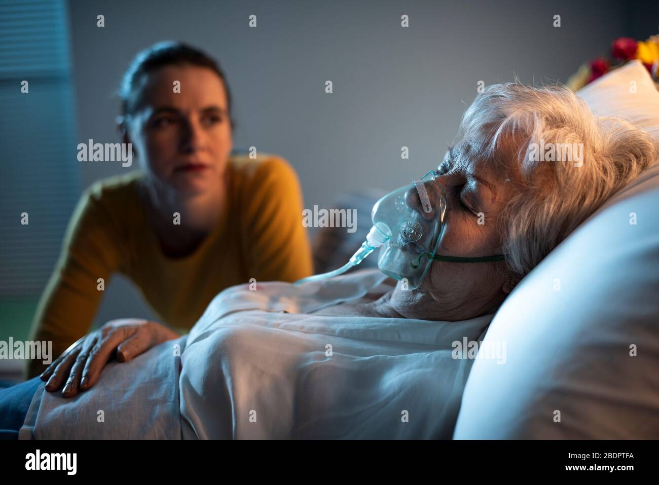 Fille triste aidant sa mère âgée malade à l'hôpital, elle est assise à côté d'elle Banque D'Images