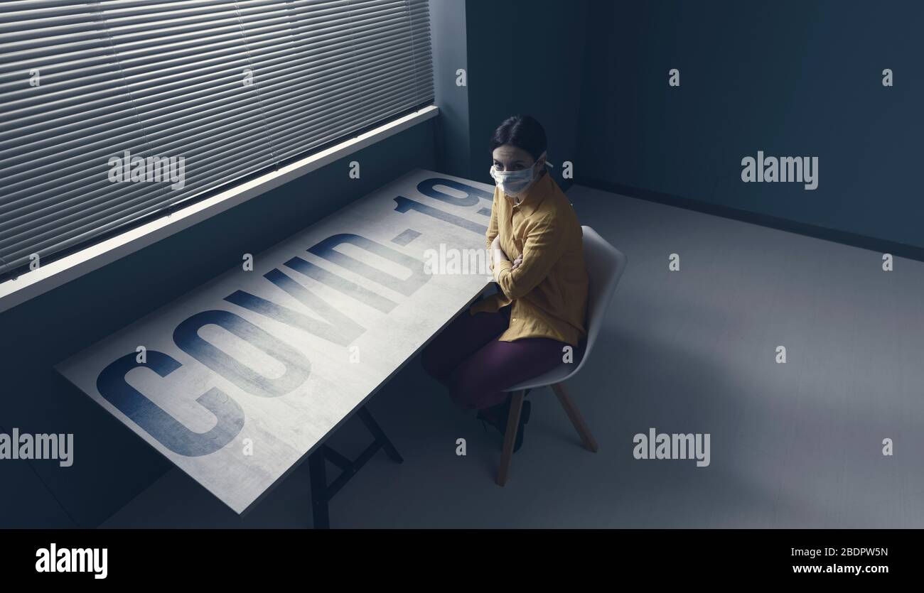 Femme solitaire en quarantaine avec covid-19 portant un masque de visage et assis à la maison seule devant une fenêtre, concept d'urgence d'épidémie de virus Banque D'Images