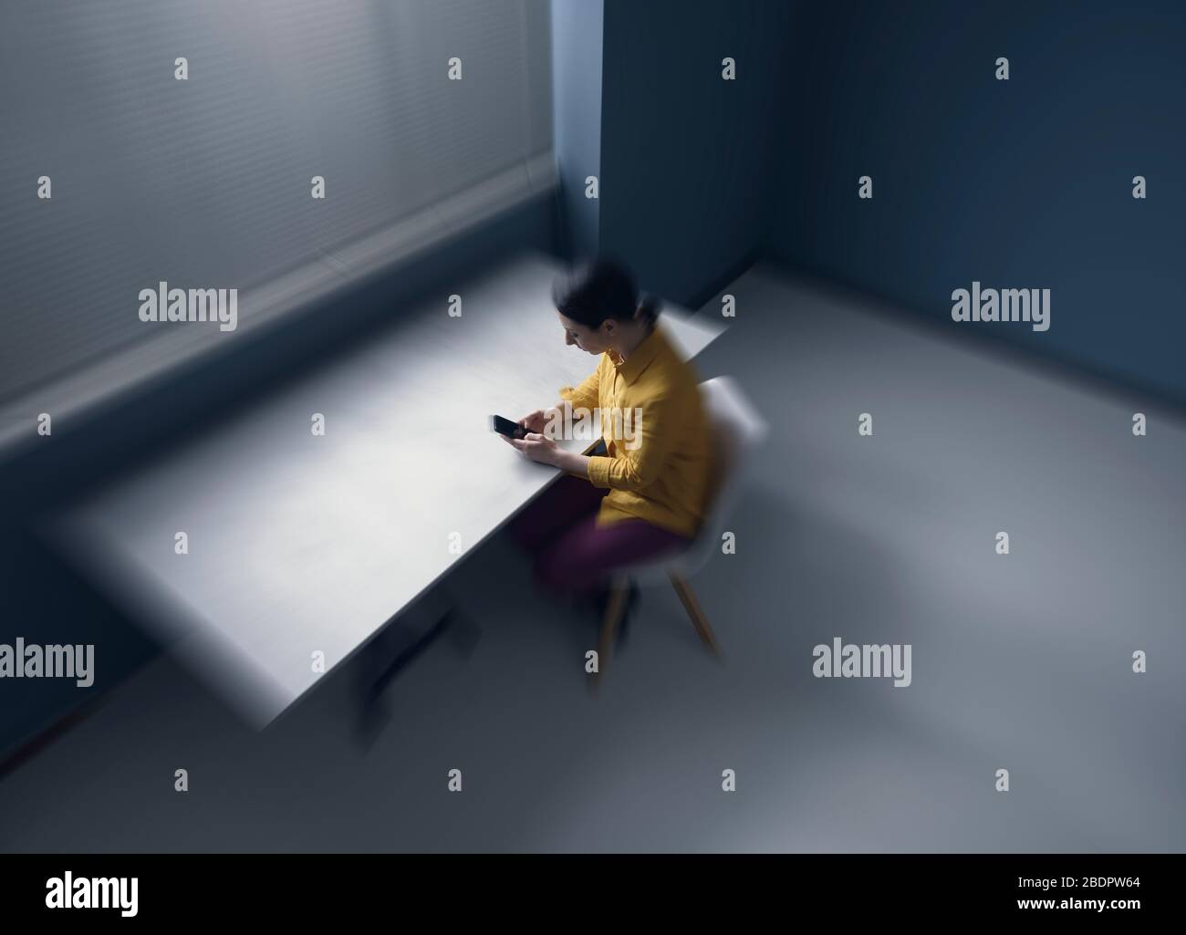Une femme triste et solitaire isolée à la maison et discutant avec son smartphone Banque D'Images
