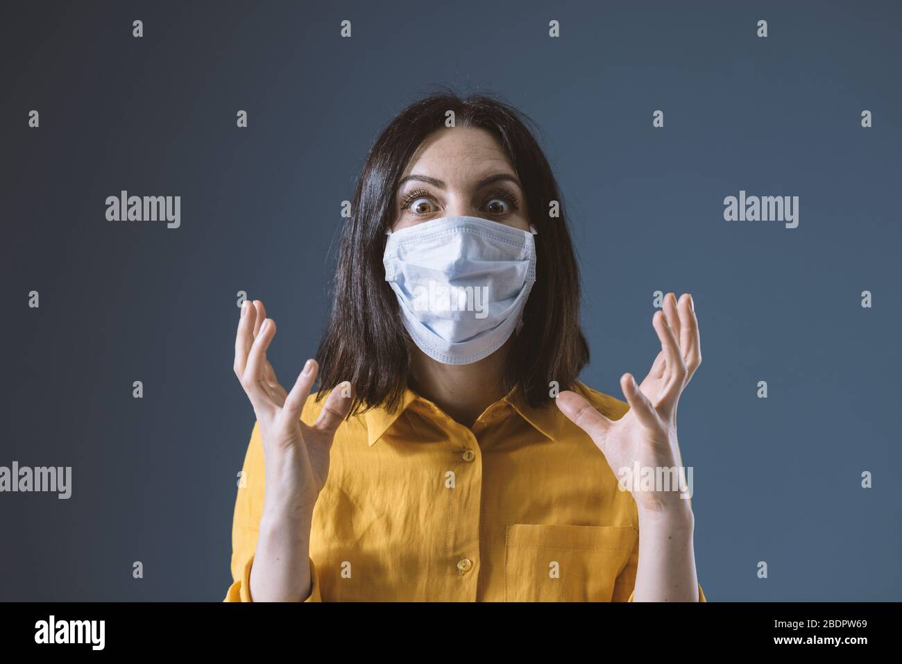 Femme paniquée portant un masque de visage contre le covid-19, elle a peur et de stress Banque D'Images