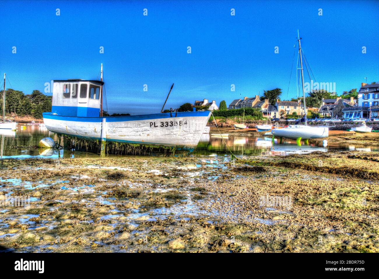 Village de Plouhmanac’h, France. Vue artistique du matin d'un bateau de pêche ancré sur les jambes du bateau au Port de Ploumanac'h. Banque D'Images