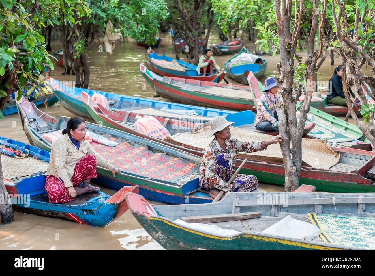 Les femmes locales invitent les touristes à profiter d'une promenade en bateau à travers les marais et les rivières de la jungle à la limite du lac Tonle SAP, Kampong Phluk, Cambodge. Banque D'Images