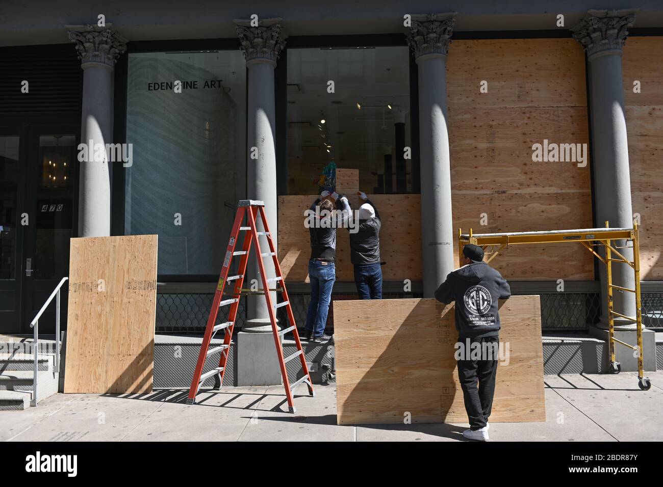 Les travailleurs s'embarquant dans les fenêtres de la galerie d'art Eden Fine dans le quartier de SoHo à New York. New York, États-Unis - 07 avril 2020 Banque D'Images