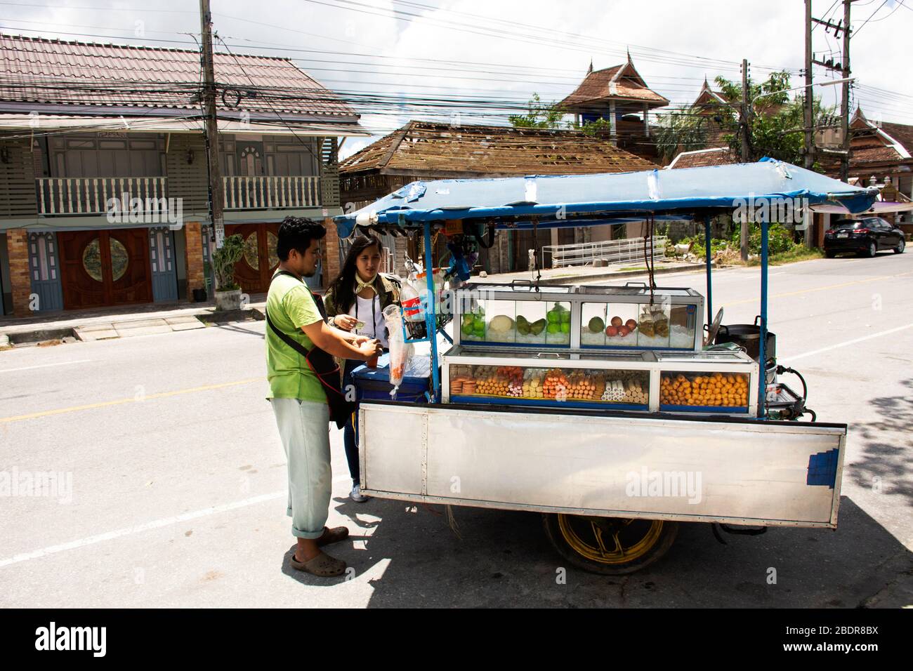 PATTANI, THAÏLANDE - 16 août : les hommes thaïlandais rôtis et grillés meatball et fruits à vendre les femmes thaïlandaises et les voyageurs étrangers dans la rue à Krue Banque D'Images