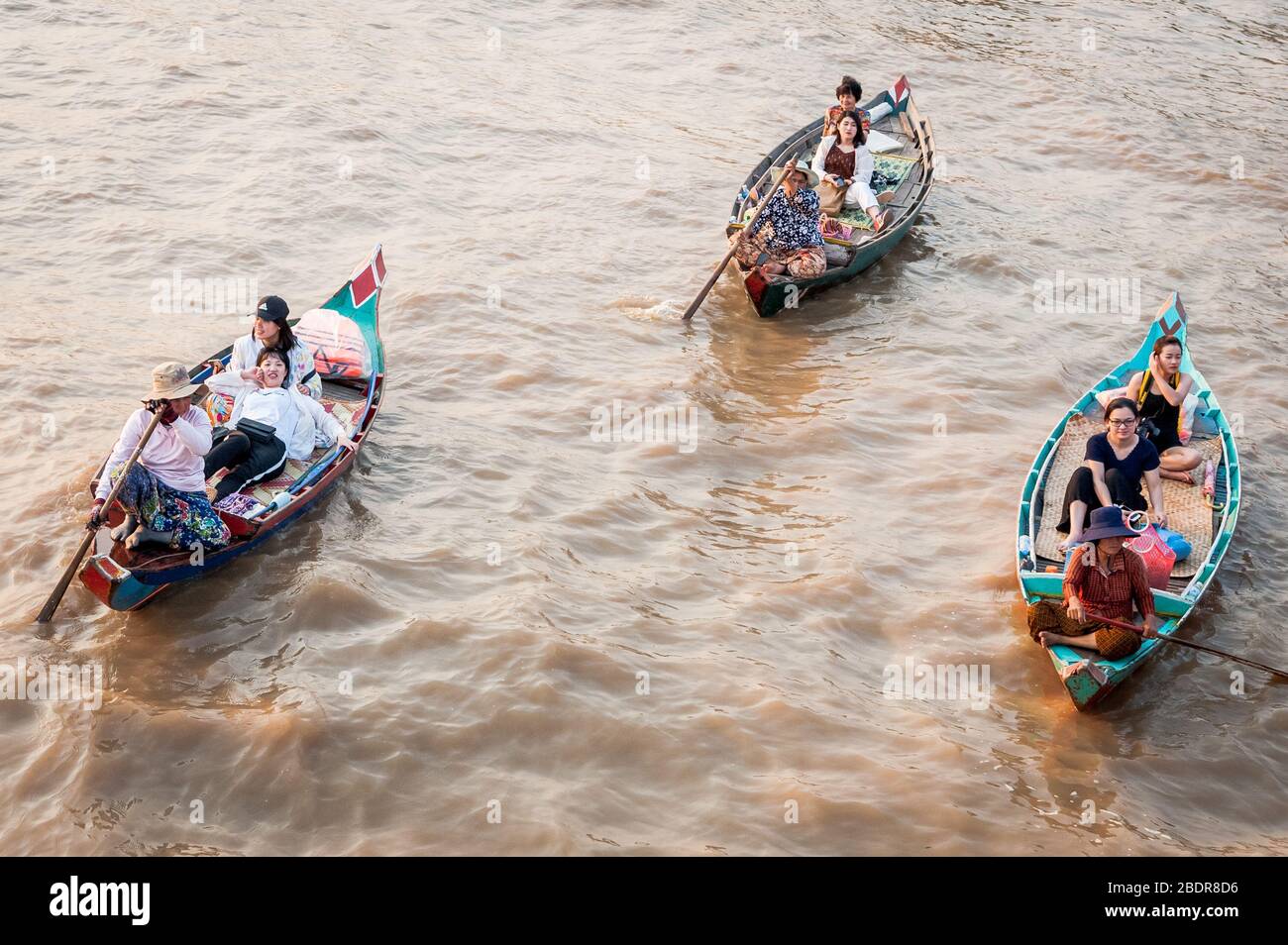 Les femmes locales invitent les touristes à profiter d'une promenade en bateau à travers les marais et les rivières de la jungle à la limite du lac Tonle SAP, Kampong Phluk, Cambodge. Banque D'Images