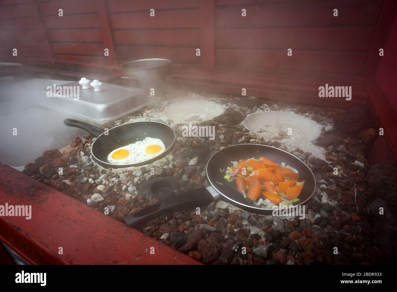Faire cuire des œufs et des légumes sur des charbons géothermiques au restaurant Kjöt og kúnst, Hveragerði Banque D'Images